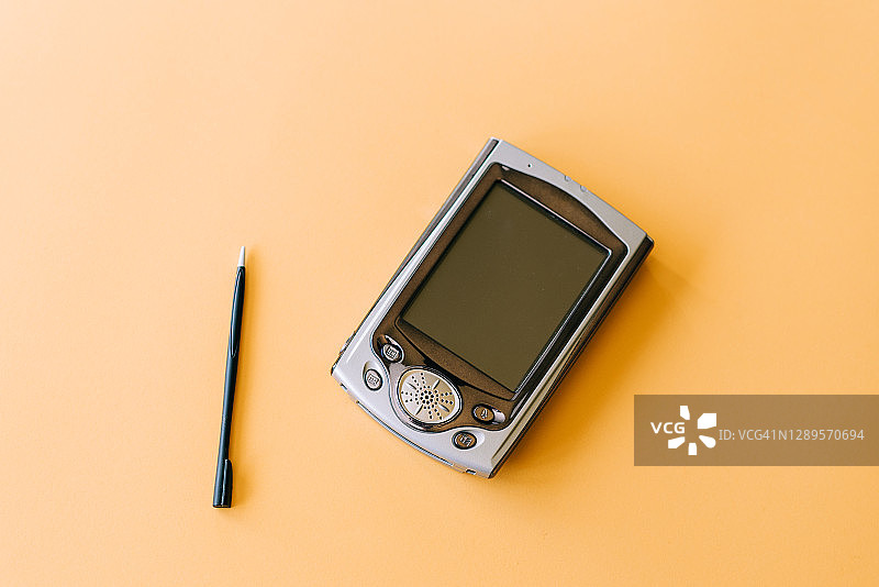 黄色背景上的老式PDA智能手机图片素材