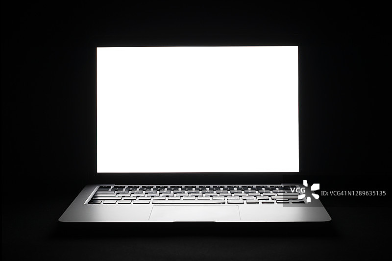 黑色背景中带白色屏幕的笔记本电脑特写图片素材