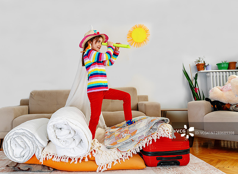 小女孩在用火把和枕头建造的船上扮演船长和水手图片素材