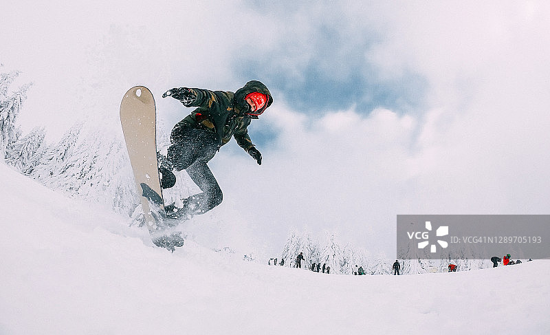 年轻男子单板滑雪的运动镜头图片素材