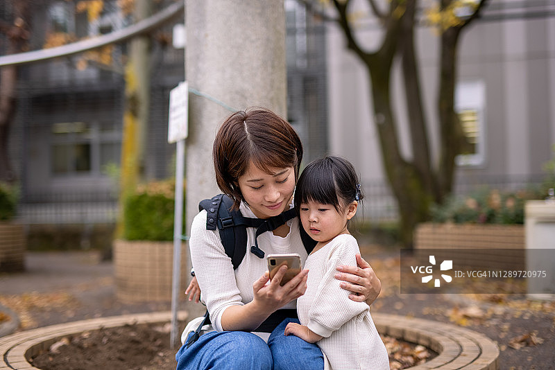 年轻的母亲在公园里照顾哭泣的女儿图片素材