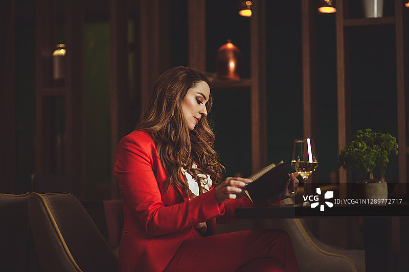 手持白葡萄酒杯的美丽女人图片素材