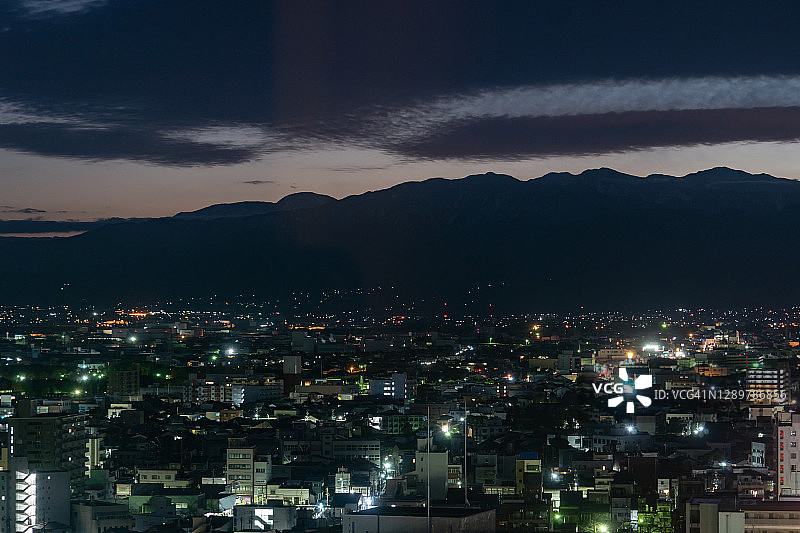 日本富山县立山及灯火通明的城市图片素材