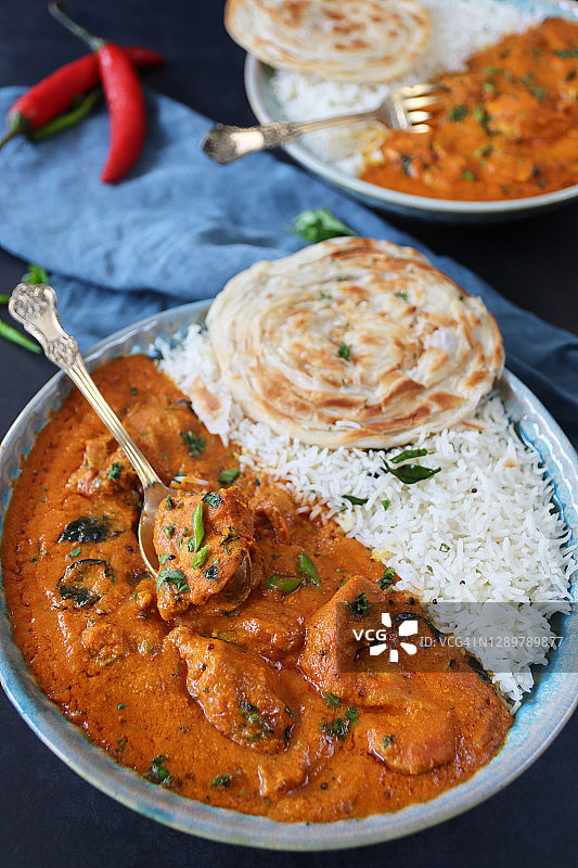 盛有黄油鸡块和米饭的蓝色盘子图片素材