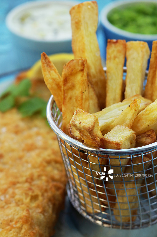 炸鱼薯条（鳕鱼）特写：配有欧芹、柠檬片和酱料图片素材