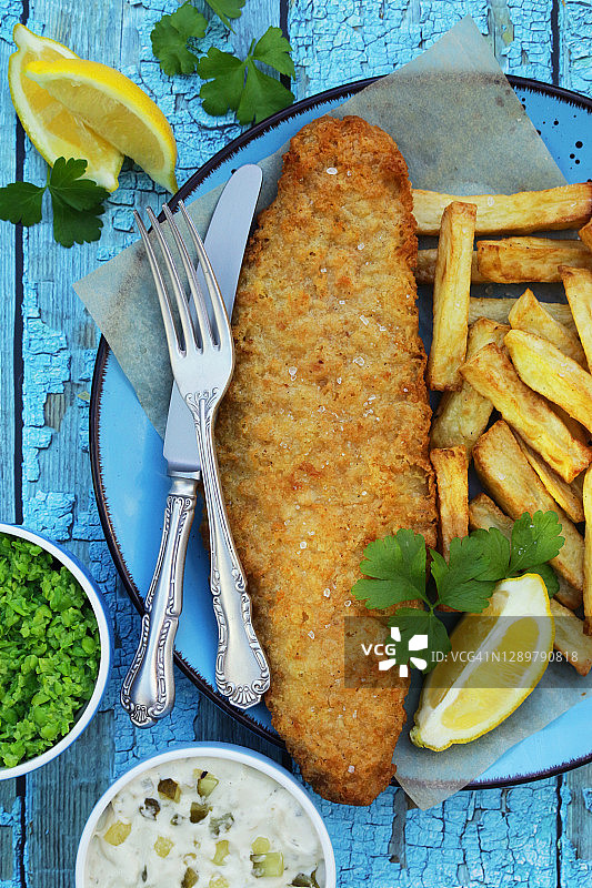 鳕鱼炸鱼薯条，配欧芹、鞑靼酱和豌豆泥图片素材