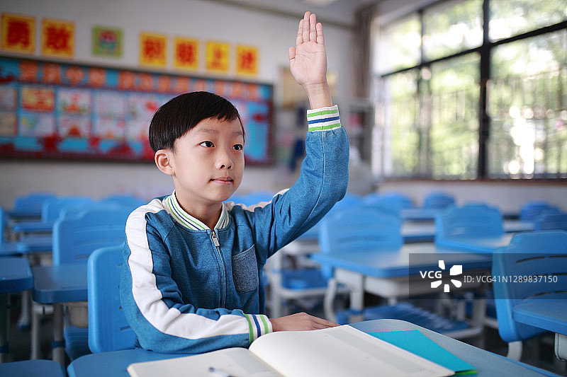 亚洲小学生在教室里做作业时思考图片素材