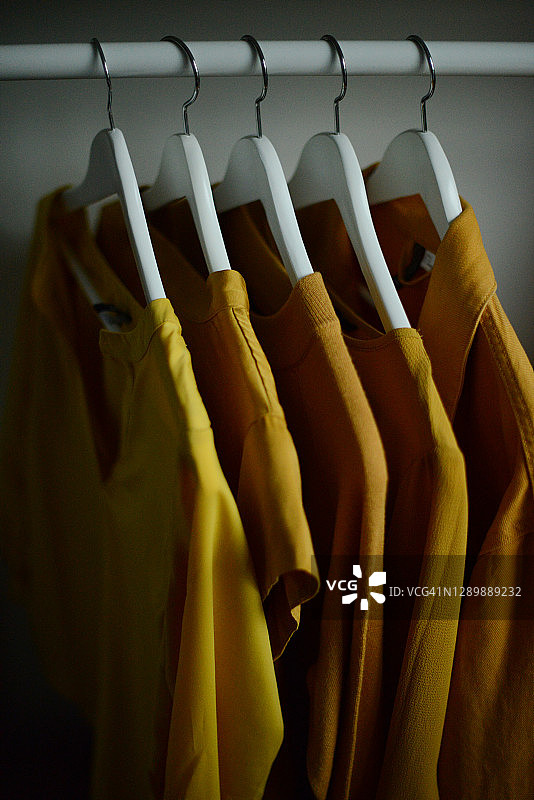 黄色衣服挂在衣架上图片素材
