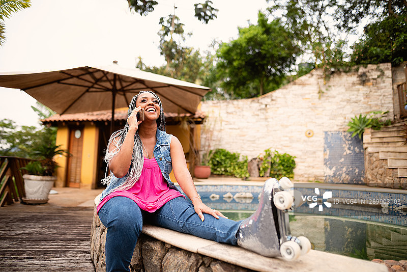 踩着旱冰鞋使用手机的黑人女性图片素材