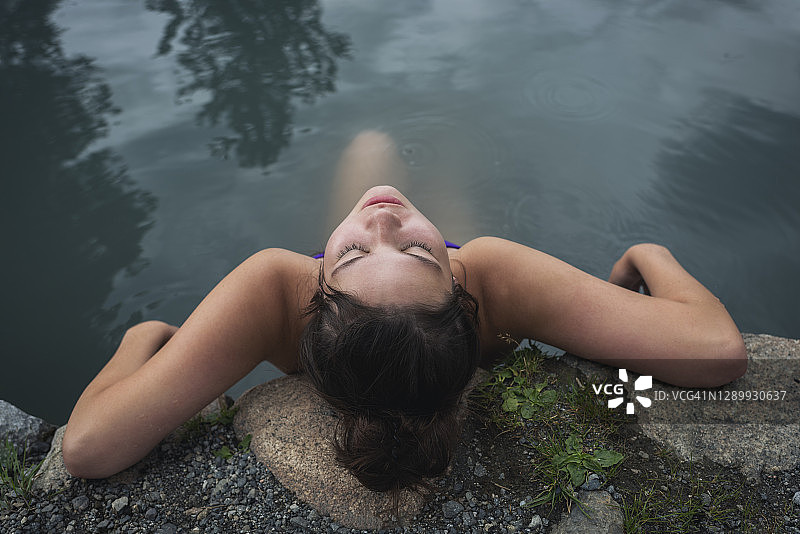 沉浸在户外温泉中的年轻女人图片素材