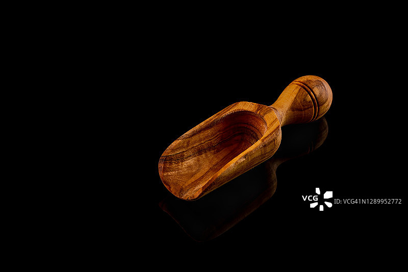 黑色背景下的橄榄木勺和抹刀图片素材