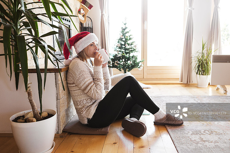 年轻女人圣诞节早上喝茶图片素材