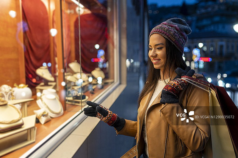 观看珠宝店橱窗的女人图片素材