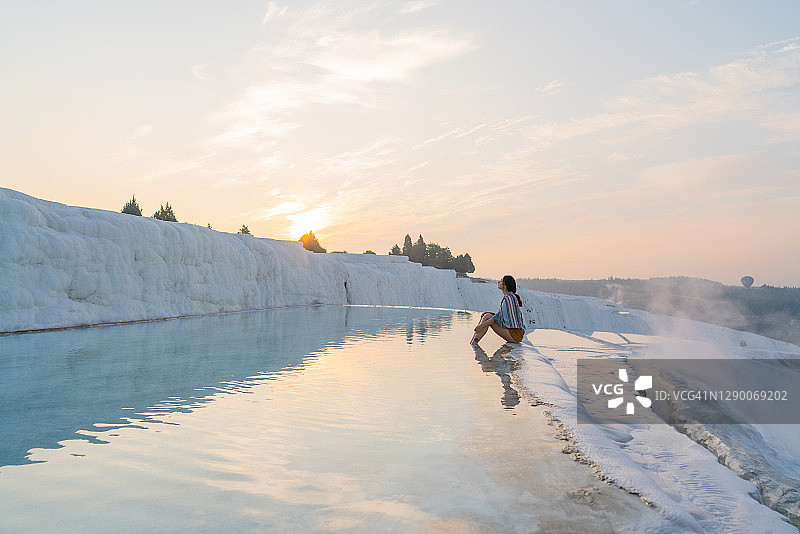坐在棉花堡石灰华水池边缘的女人图片素材