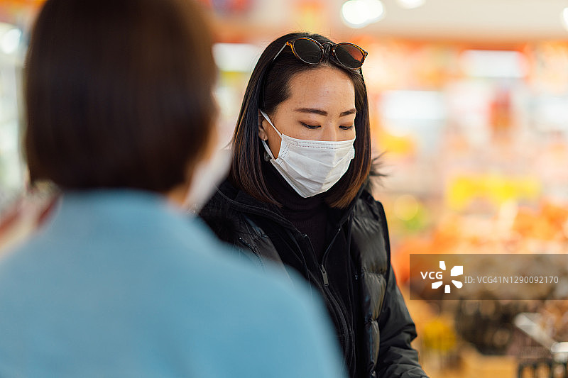朋友们戴着防护口罩在超市购买食品图片素材