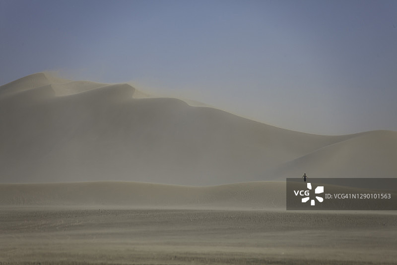 在加利福尼亚州迪蒙沙丘沙尘暴中站在沙丘上的人图片素材