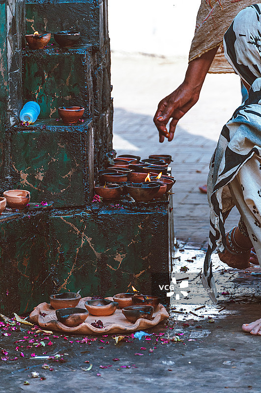 在神殿中点燃油灯的妇女图片素材