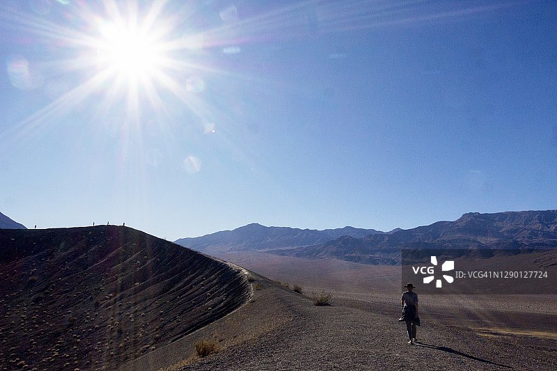 火山口边缘的徒步者剪影图片素材