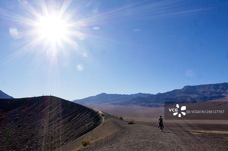 火山口边缘的徒步者剪影图片素材