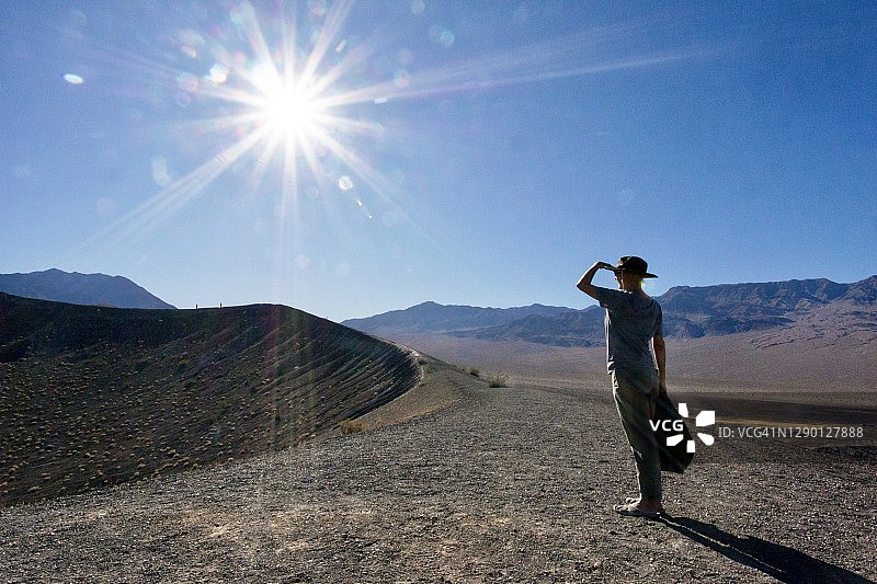 女人遮着眼睛看火山坑边缘图片素材