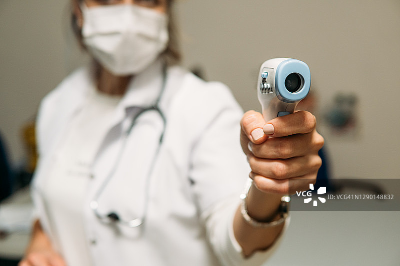 疫情期间医生用电子温度计测量病人体温图片素材
