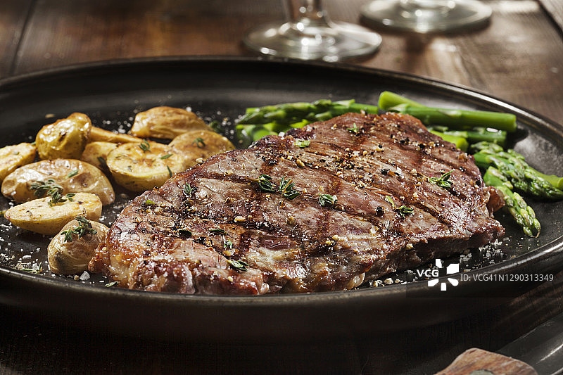 搭配烤土豆和蒸芦笋的五分熟西冷牛排图片素材
