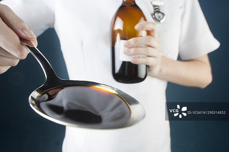 医务人员手拿一勺药图片素材