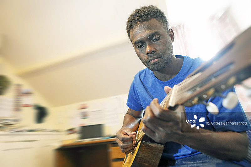 在卧室里弹吉他的男人图片素材