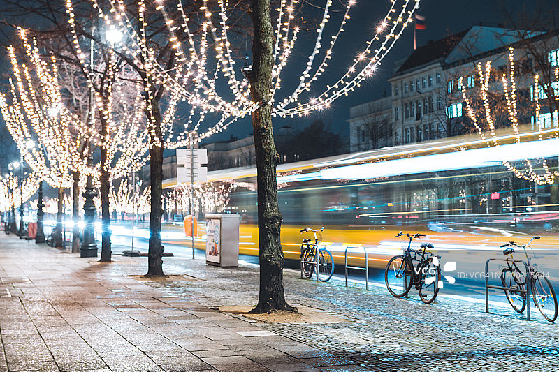 柏林菩提树下节日彩灯旁的黄色巴士图片素材