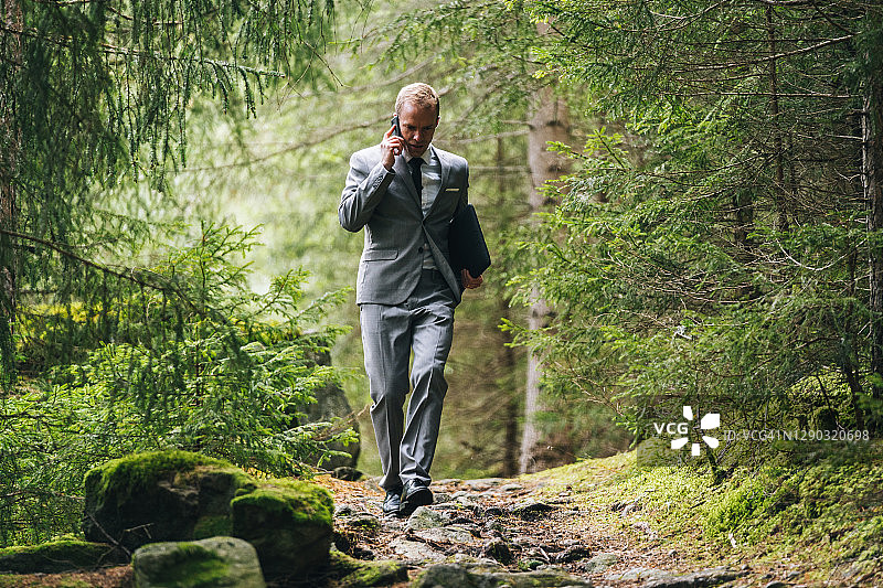 商务男士在茂密的森林中远程办公图片素材