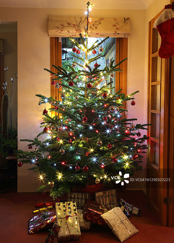 蓝色云杉圣诞树装饰的童话灯和小玩意。图片素材