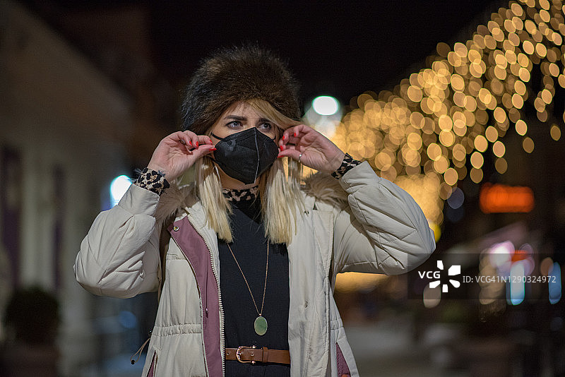 在城镇里戴口罩的年轻女孩图片素材