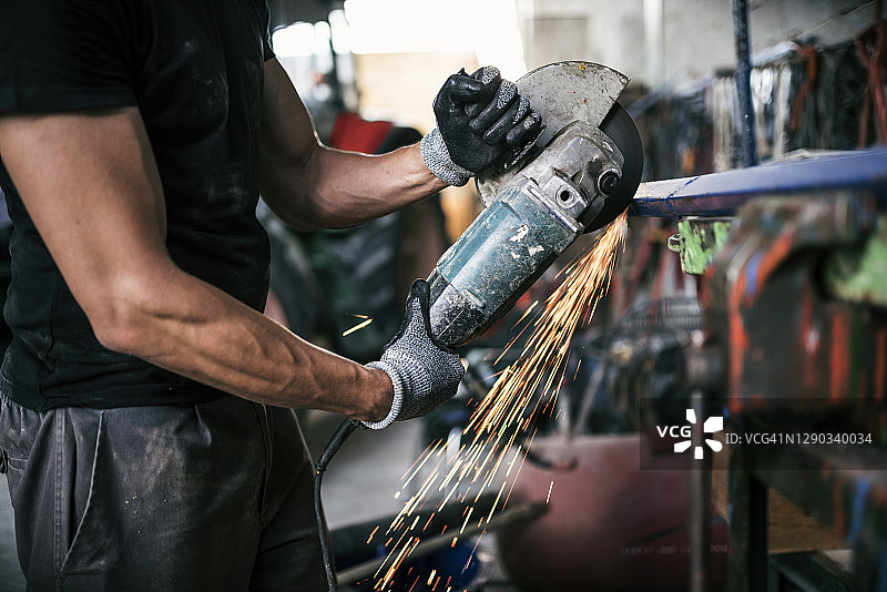 仓库工人安全操作，在车床上用径向锯切割金属图片素材