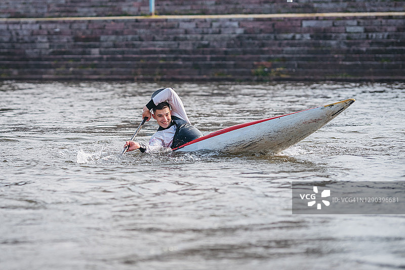在静水中进行皮划艇短跑训练的年轻健壮男人图片素材
