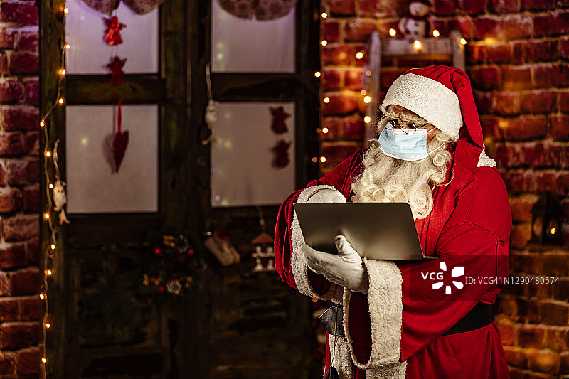 圣诞节前使用电脑的圣诞老人图片素材