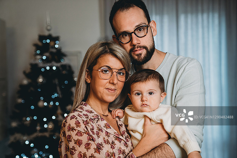 在家中圣诞树旁的家庭合影图片素材