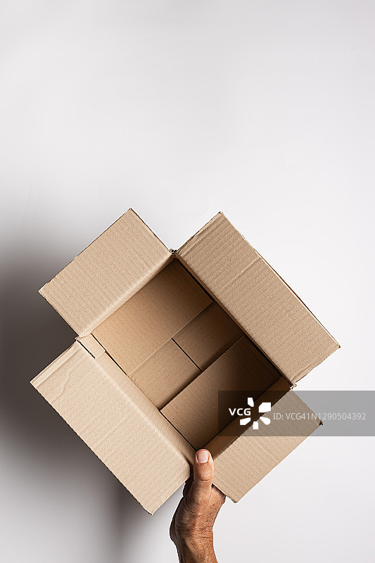 俯视视角：手拿纸板箱，白色背景图片素材