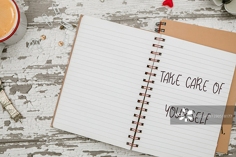 女性工作区笔记本上写着“照顾好自己”图片素材