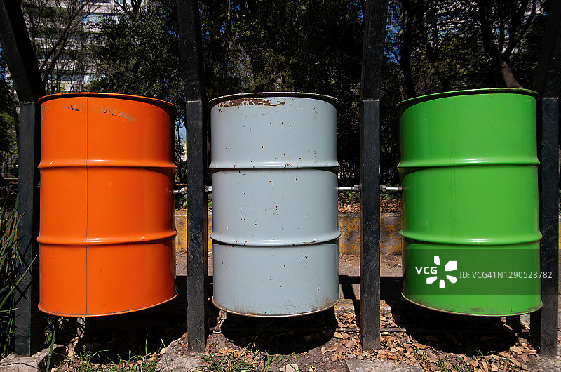 公园里的垃圾分类收集箱：不可回收垃圾（橙色），可回收无机物（灰色），有机垃圾（绿色）图片素材