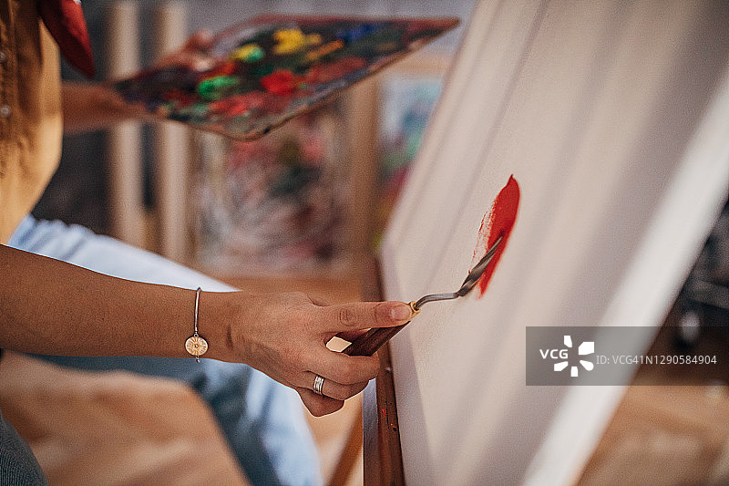 女艺术家用刮刀绘画图片素材