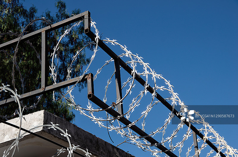 晴空下安全围栏顶部的刀片刺网图片素材