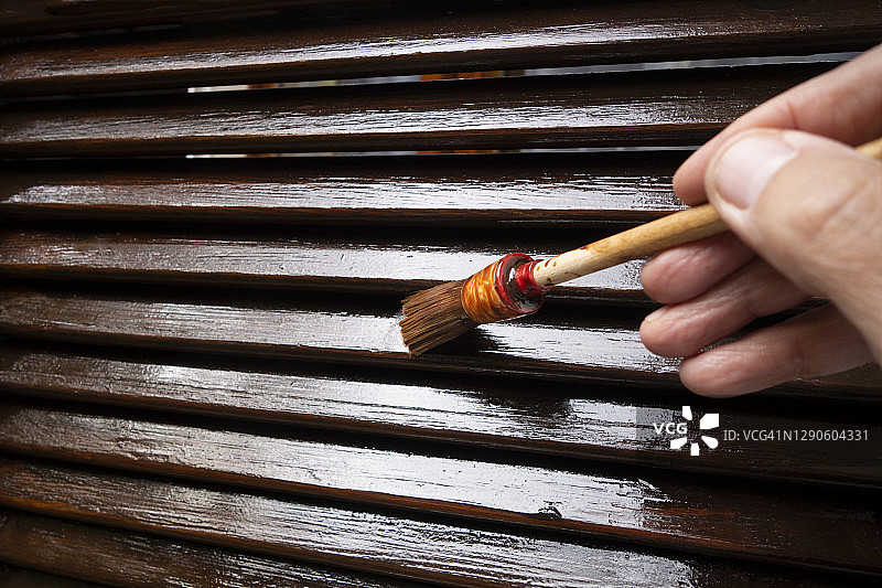 给木制百叶窗上漆的人图片素材