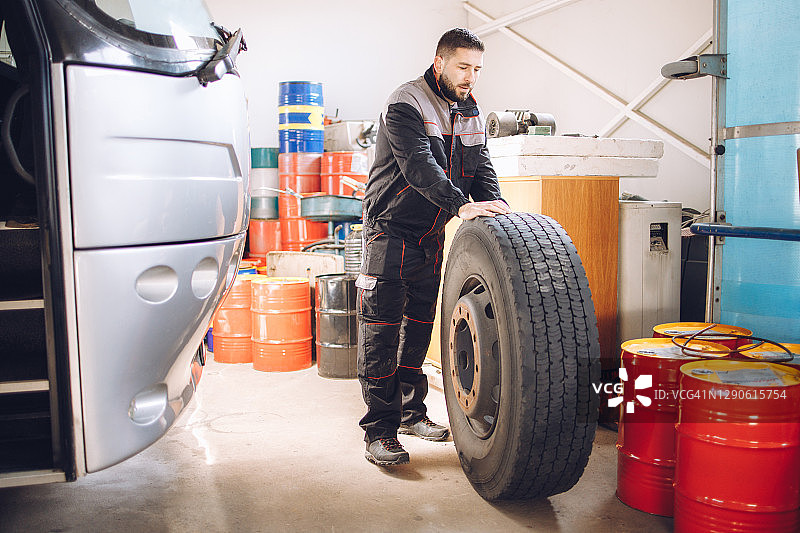 技工在修理厂更换巴士车轮图片素材