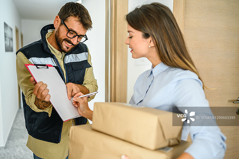 女人从快递员手中收到包裹图片素材