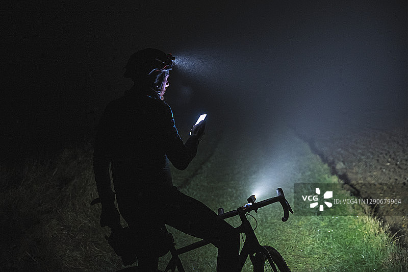 骑行者在雾蒙蒙的傍晚用手机查看方向图片素材
