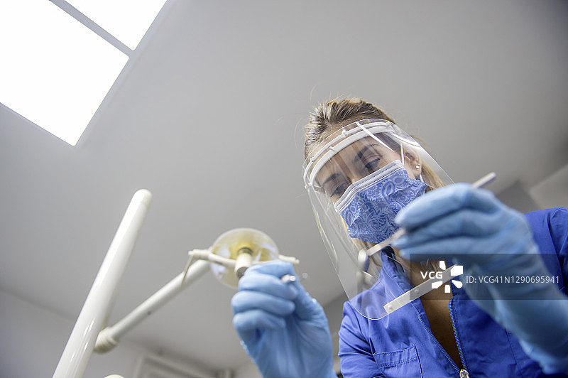 戴防护口罩和面罩的牙医图片素材