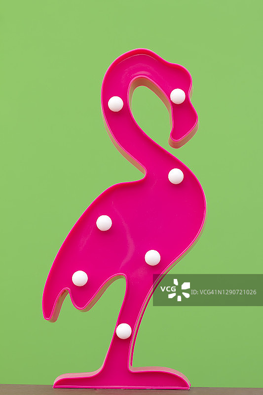 绿色背景下的粉色塑料火烈鸟图片素材