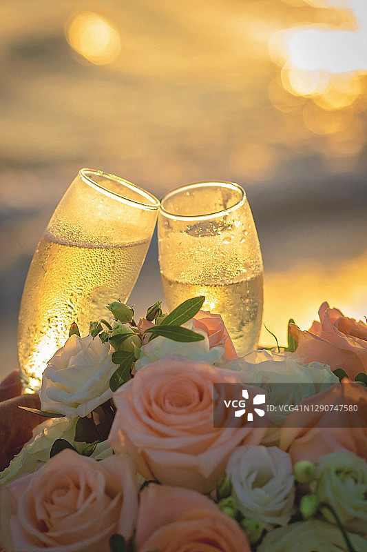 日落时分举起香槟酒杯的手图片素材