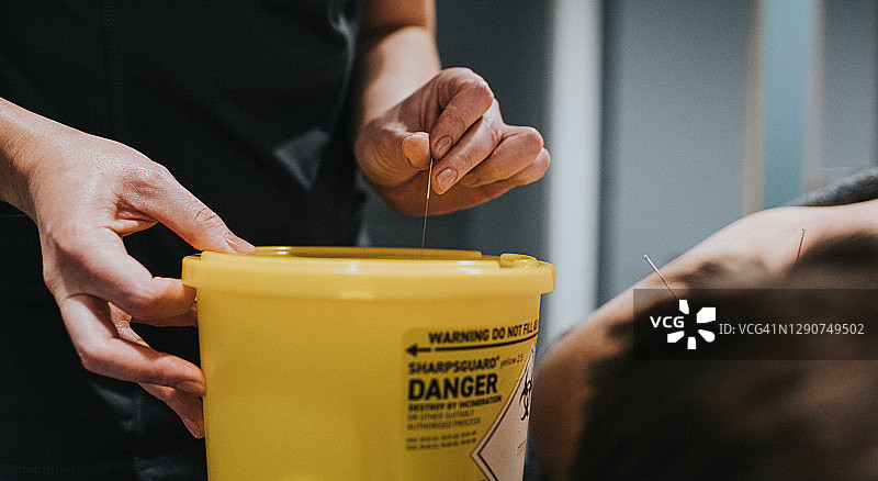 将针灸针丢入医疗废物桶图片素材