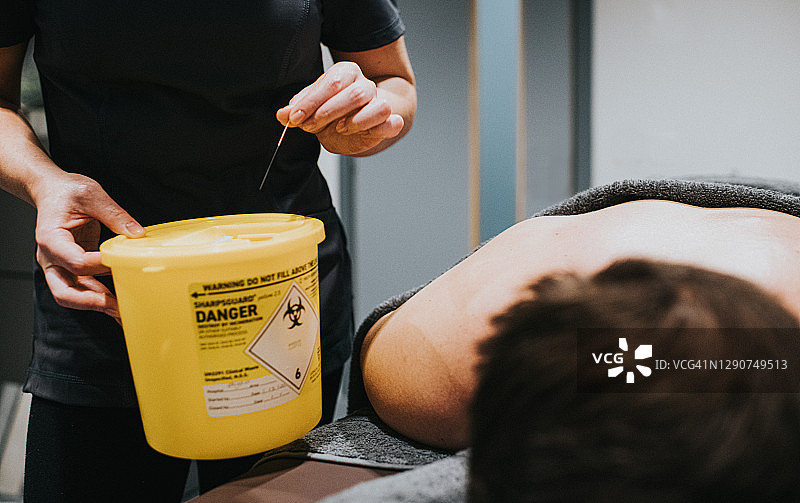 将针灸针丢入医疗废物桶图片素材